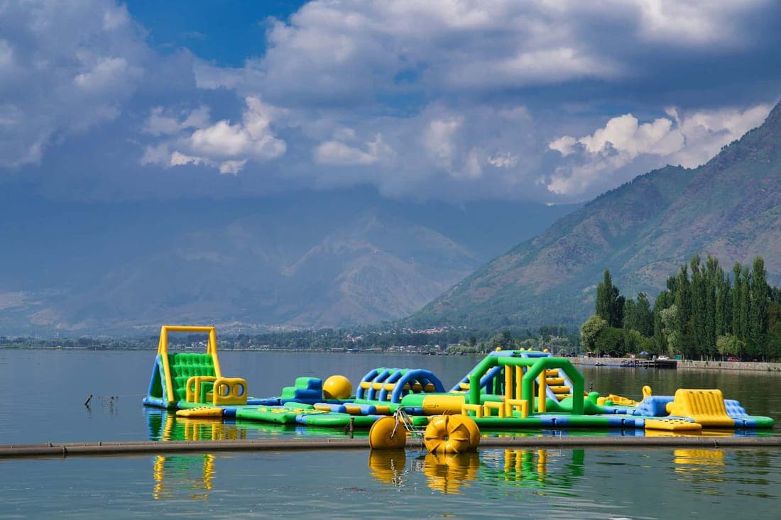 Vibrant inflatable obstacle course on a tranquil alpine lake surrounded by mountains