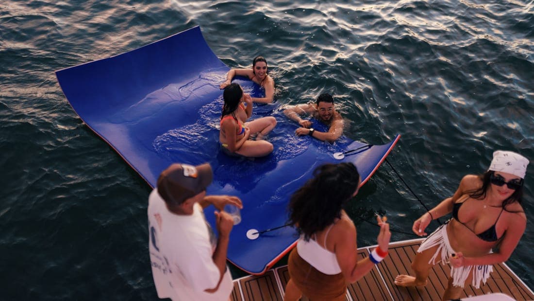A lively group enjoying a summer day on a floating mat in the water