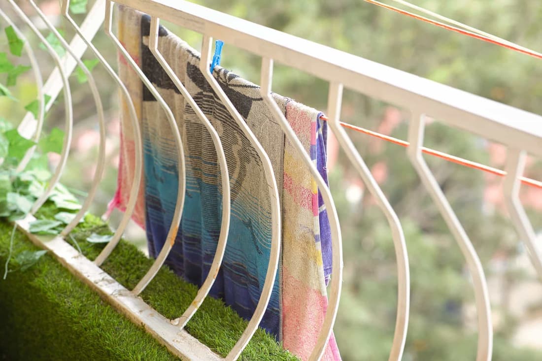 Vivid towels hanging on a balcony railing to dry in the outdoor breeze in Kenya